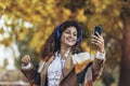 Woman listening to music and breathing fresh air in autumn in a forest or park Royalty Free Stock Photo