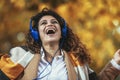 Woman listening to music and breathing fresh air in autumn in a forest or park Royalty Free Stock Photo