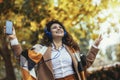 Woman listening to music and breathing fresh air in autumn in a forest or park Royalty Free Stock Photo