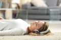 Relaxed woman listening to music on the floor Royalty Free Stock Photo