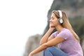 Relaxed woman listening to music in the mountain