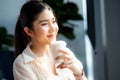 Relaxed woman looking away drinking coffee at home looking out the window enjoying the new day Royalty Free Stock Photo