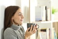 Relaxed woman looks away in winter holding coffee mug Royalty Free Stock Photo