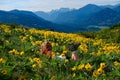 Relaxed woman lying down on meadows with yellow joyful flowers. Royalty Free Stock Photo