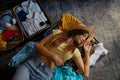 Relaxed woman lying on opened suitcase with prepared clothes for travel Royalty Free Stock Photo