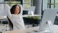 Relaxed woman manager taking break at workplace holding hands behind head resting after completing work sitting at desk Royalty Free Stock Photo