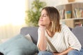 Relaxed woman meditating sitting on a couch at home