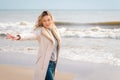 Relaxed woman,outstretched hands, enjoying spring sun, on a beautiful beach. Young lady feeling free, relaxed and happy Royalty Free Stock Photo