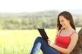 Relaxed woman reading an ebook in the country