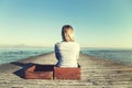 Relaxed woman sitting in her big suitcase after a long journey