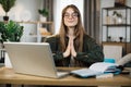 Relaxed woman sitting on workplace with modern laptop and meditating with closed eyes Royalty Free Stock Photo