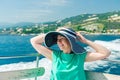 Relaxed woman in sun hat enjoying ocean voyage, sailing on the luxury