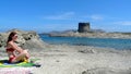 Relaxed woman taking the sun in Pelosa beach, Sardinia, Italy Royalty Free Stock Photo