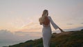 Relaxed woman walking hill at evening. Flying hair girl turning around posing