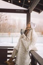 Relaxed woman in warm winter clothes plaid drinking hot cocoa coffee tea outdoor winter nature Royalty Free Stock Photo