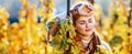 Relaxed woman winegrower standing in vineyard outdoors in autumn