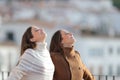 Relaxed women breathing fresh air in a balcony