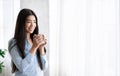 Relaxed Young Asian Girl Enjoying Morning Coffee Near Window At Home Royalty Free Stock Photo