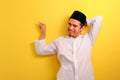 Relaxed young Asian Muslim man with a blissful smile leaning back pointing a copy space to presenting something Royalty Free Stock Photo