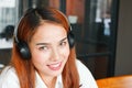Relaxed young Asian woman listening music with headphones in living room Royalty Free Stock Photo