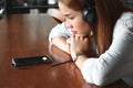 Relaxed young Asian woman listening music with headphones in living room. Royalty Free Stock Photo