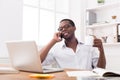 Relaxed young black businessman call mobile phone in modern white office Royalty Free Stock Photo