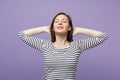 Relaxed young brunette woman girl in casual striped clothes posing isolated on violet purple background studio portrait Royalty Free Stock Photo