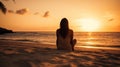 A relaxed young brunette woman or girl wearing a bikini sitting on a deserted tropical beach at sunset or sunrise Royalty Free Stock Photo