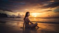 A relaxed young brunette woman or girl wearing a bikini sitting on a deserted tropical beach at sunset or sunrise Royalty Free Stock Photo