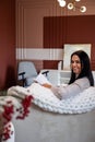 Relaxed young brunette woman reading fashion magazine sitting on comfy couch at comfortable home Royalty Free Stock Photo