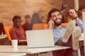 Relaxed young businessman at workplace at early morning, at startup office. Royalty Free Stock Photo