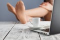 relaxed young businesswoman sitting with legs on desk in a bright office Royalty Free Stock Photo