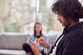 Relaxed Young Couple At Home Sitting On Sofa Using Digital Tablet And Mobile Phone Royalty Free Stock Photo