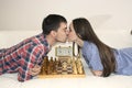 Relaxed young couple playing chess at home lying on sofa. won - Friendship.