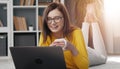 Brunette holding cup looking laptop Royalty Free Stock Photo