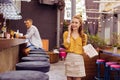 Relaxed young girl talking on the phone while visiting popular bar Royalty Free Stock Photo