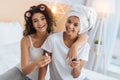 Relaxed young ladies smiling while preparing for celebration Royalty Free Stock Photo