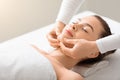 Relaxed young lady having lifting face massage at spa Royalty Free Stock Photo