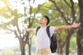 Relaxed young man breathing deeply fresh air in a forest with green trees