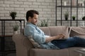 Relaxed young man lying on sofa with computer on laps. Royalty Free Stock Photo