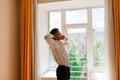 Relaxed young man resting from work. Man enjoy break stretching in home office workplace, isolation