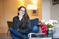 Relaxed young woman with beautiful smile sitting on the chair in the living room Royalty Free Stock Photo