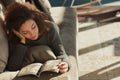 Curly-haired young woman, relaxed, sprawling on couch, spacious
