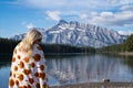 Relaxed young woman draped in a pumpkin blanket enjoys the view at Two Jack Lake in Banff National Park Royalty Free Stock Photo