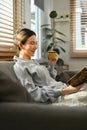 Relaxed young woman drinking hot coffee and reading book, spending free time in Sunday morning at home Royalty Free Stock Photo