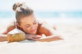 Relaxed young woman laying on beach with coconut Royalty Free Stock Photo