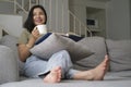 Relaxed young woman sitting on sofa and drinking hot coffee, enjoying weekend at home Royalty Free Stock Photo