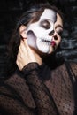 Relaxed young woman with skull make up touching neck.