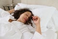 Relaxed young woman sleeping in her bed covered with white soft blanket. Woman napping in the morning. Its time to we up Royalty Free Stock Photo