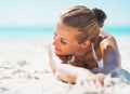 Relaxed young woman in swimsuit laying on sandy beach Royalty Free Stock Photo